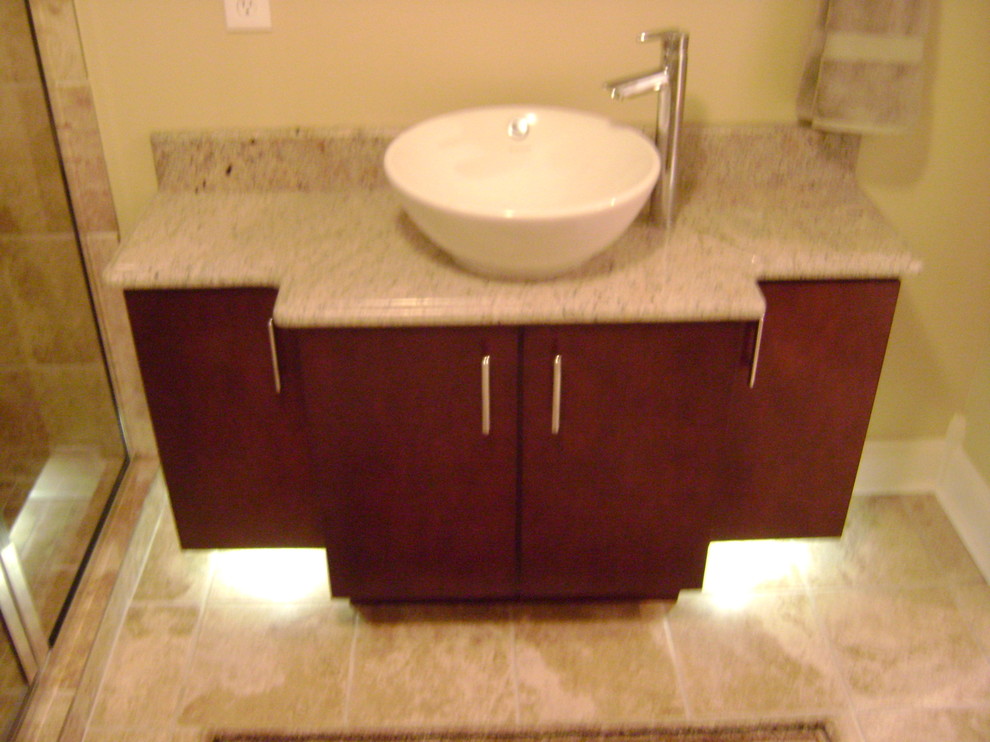 This is an example of a medium sized contemporary ensuite bathroom in Detroit with a vessel sink, flat-panel cabinets, medium wood cabinets, granite worktops, a corner shower, beige tiles, ceramic tiles, beige walls and ceramic flooring.