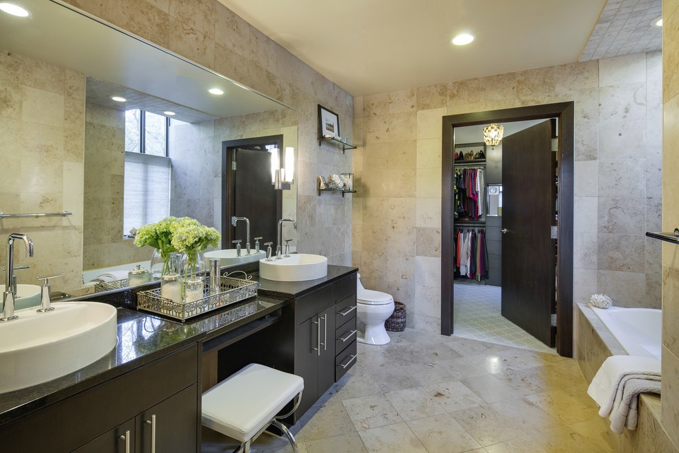 Источник вдохновения для домашнего уюта: главная ванная комната в современном стиле с плоскими фасадами, темными деревянными фасадами, накладной ванной, бежевой плиткой и настольной раковиной
