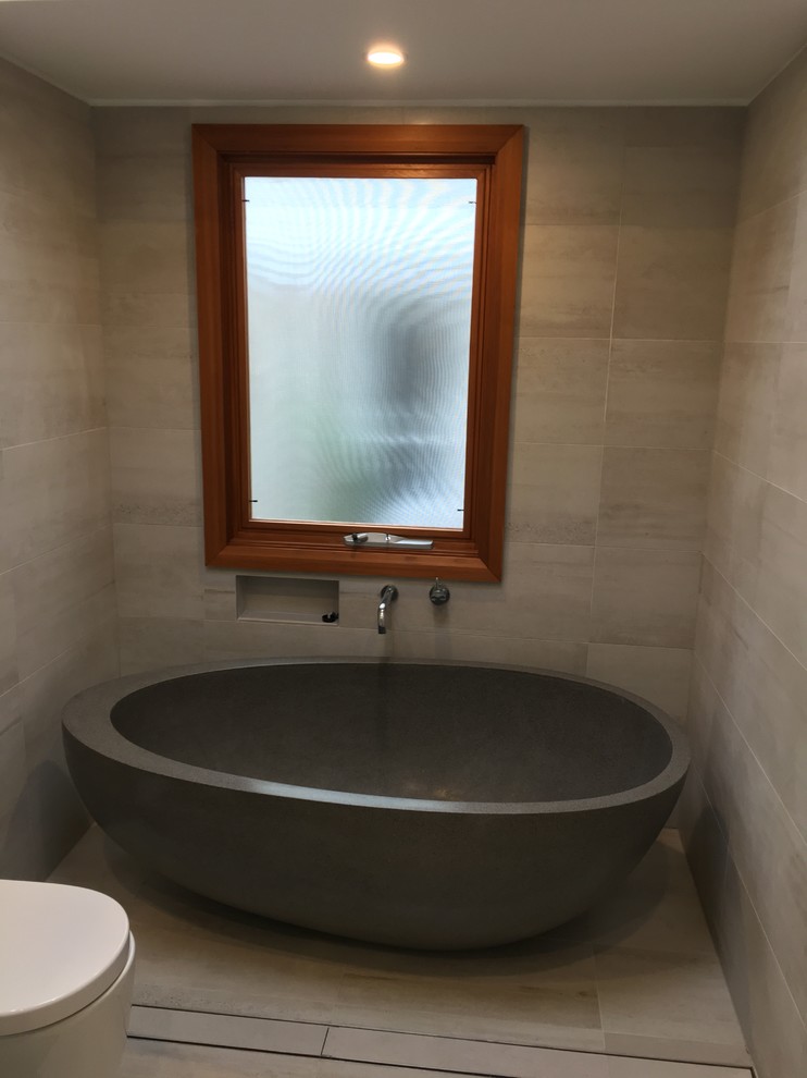 This is an example of a contemporary ensuite bathroom in Sydney with open cabinets, white cabinets, a freestanding bath, a corner shower, beige tiles, ceramic tiles, a vessel sink and quartz worktops.