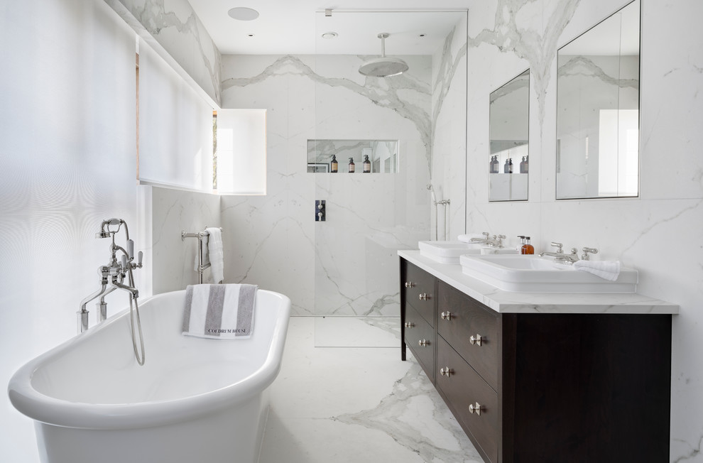 Пример оригинального дизайна: ванная комната среднего размера: освещение в классическом стиле с плоскими фасадами, коричневыми фасадами, отдельно стоящей ванной, открытым душем, белой плиткой, мраморным полом, накладной раковиной, мраморной столешницей, открытым душем и мраморной плиткой