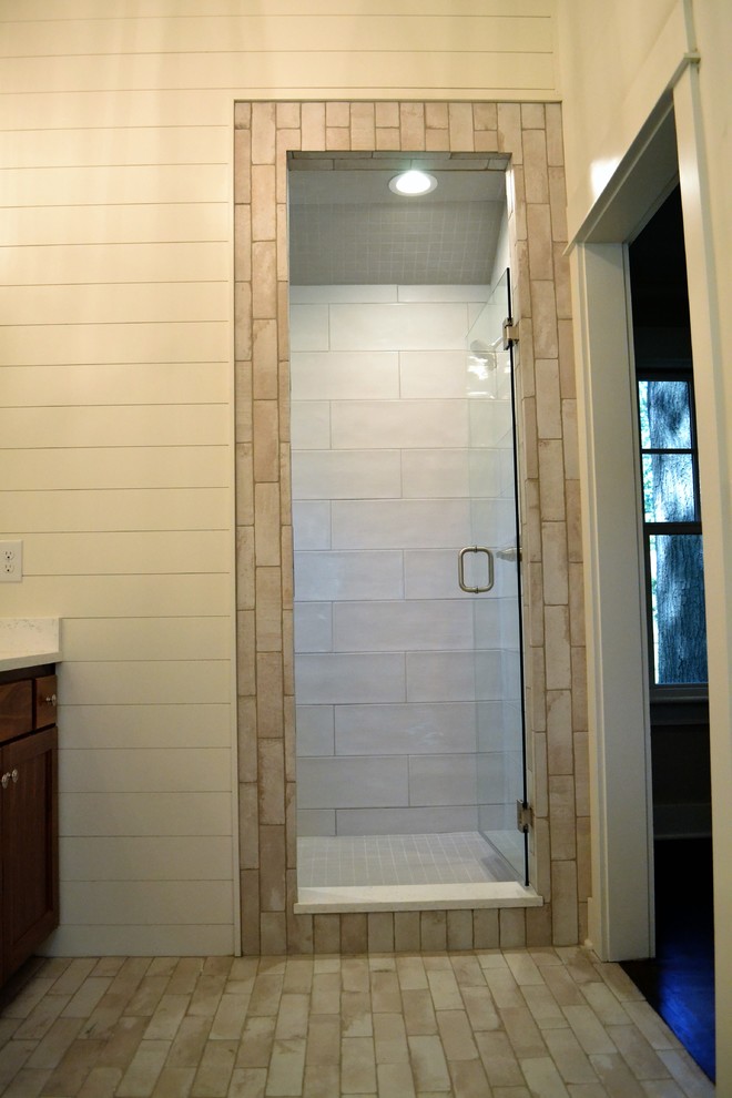 Exempel på ett mellanstort lantligt en-suite badrum, med skåp i shakerstil, skåp i mellenmörkt trä, en dusch i en alkov, beige kakel, porslinskakel, beige väggar, ett undermonterad handfat, marmorbänkskiva och dusch med gångjärnsdörr