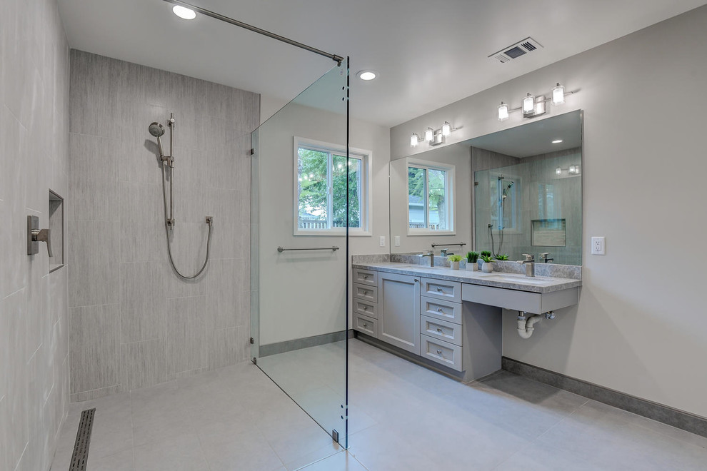 Exempel på ett stort modernt grå grått en-suite badrum, med luckor med infälld panel, grå skåp, en kantlös dusch, en toalettstol med hel cisternkåpa, grå kakel, keramikplattor, grå väggar, klinkergolv i keramik, ett nedsänkt handfat, bänkskiva i kvartsit, grått golv och dusch med gångjärnsdörr