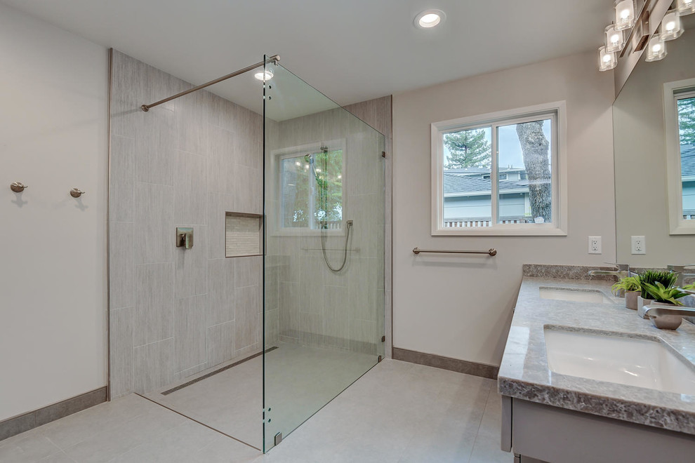 Inredning av ett modernt stort grå grått en-suite badrum, med luckor med infälld panel, grå skåp, en kantlös dusch, en toalettstol med hel cisternkåpa, grå kakel, keramikplattor, grå väggar, klinkergolv i keramik, ett nedsänkt handfat, bänkskiva i kvartsit, grått golv och dusch med gångjärnsdörr