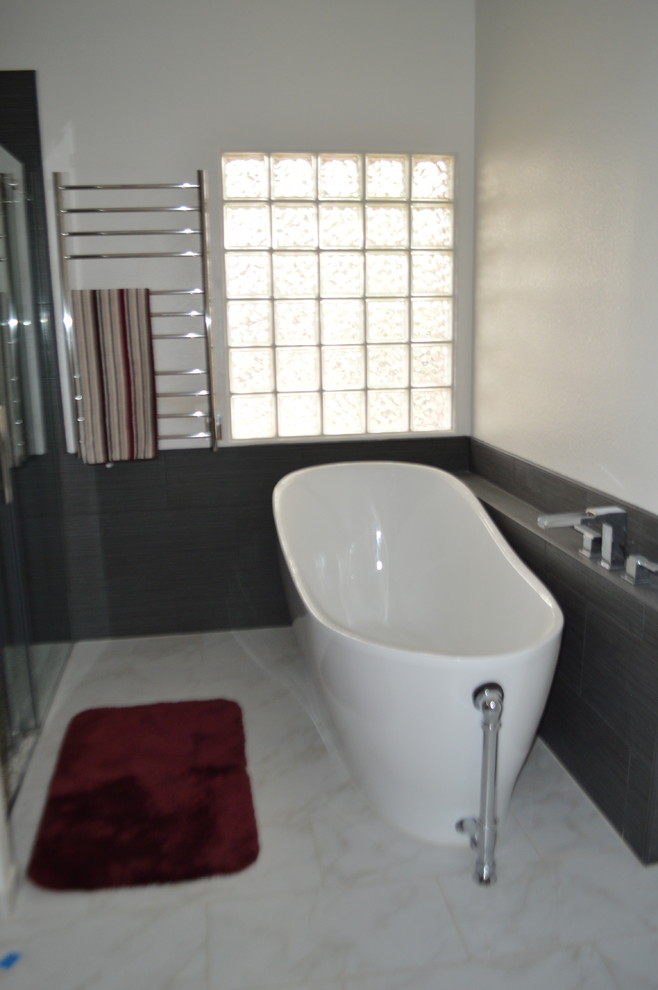 Idéer för att renovera ett funkis flerfärgad flerfärgat badrum, med skåp i shakerstil, vita skåp, en dusch i en alkov, en toalettstol med separat cisternkåpa, svart kakel, kakel i småsten, grå väggar, klinkergolv i porslin, ett undermonterad handfat, bänkskiva i kvarts, grått golv och dusch med skjutdörr