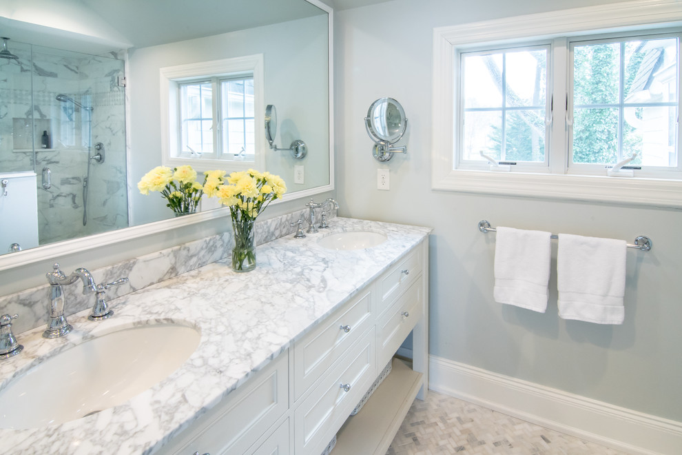 Idéer för att renovera ett stort amerikanskt en-suite badrum, med luckor med infälld panel, vita skåp, vit kakel, blå väggar, marmorgolv, ett undermonterad handfat, marmorbänkskiva, en dusch i en alkov, marmorkakel, vitt golv och dusch med gångjärnsdörr