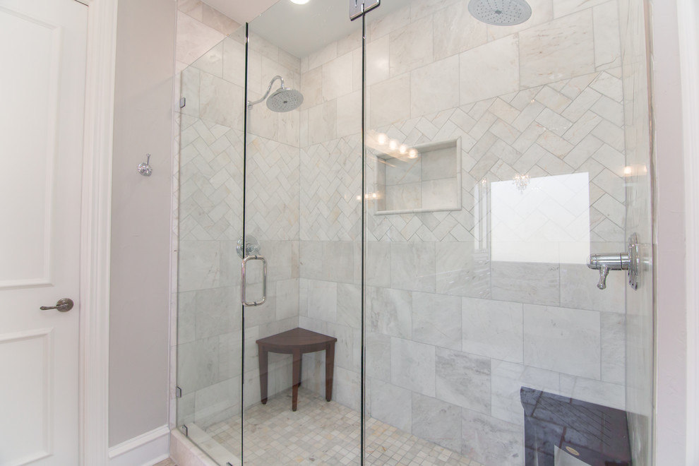 Photo of a large contemporary ensuite bathroom in Dallas with white cabinets, a freestanding bath, a double shower, a two-piece toilet, grey walls, travertine flooring, a submerged sink, marble worktops, grey floors, a hinged door, white worktops, glass-front cabinets, white tiles and stone tiles.
