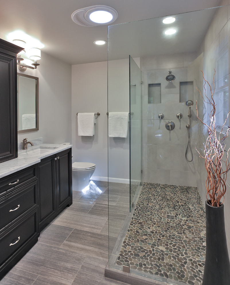 Example of a mid-sized transitional master gray tile and porcelain tile porcelain tile doorless shower design in DC Metro with an undermount sink, dark wood cabinets, marble countertops, a two-piece toilet, gray walls and recessed-panel cabinets