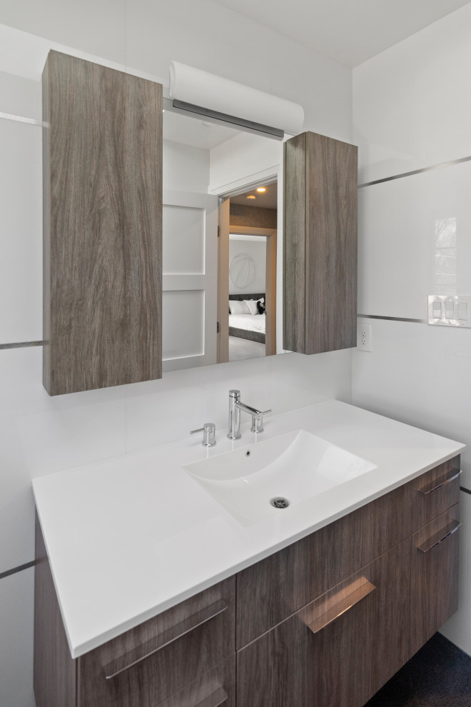 Inspiration for a medium sized modern bathroom with flat-panel cabinets, medium wood cabinets, a shower/bath combination, white tiles, glass tiles, white walls, a console sink, marble worktops, black floors, a hinged door, white worktops and panelled walls.