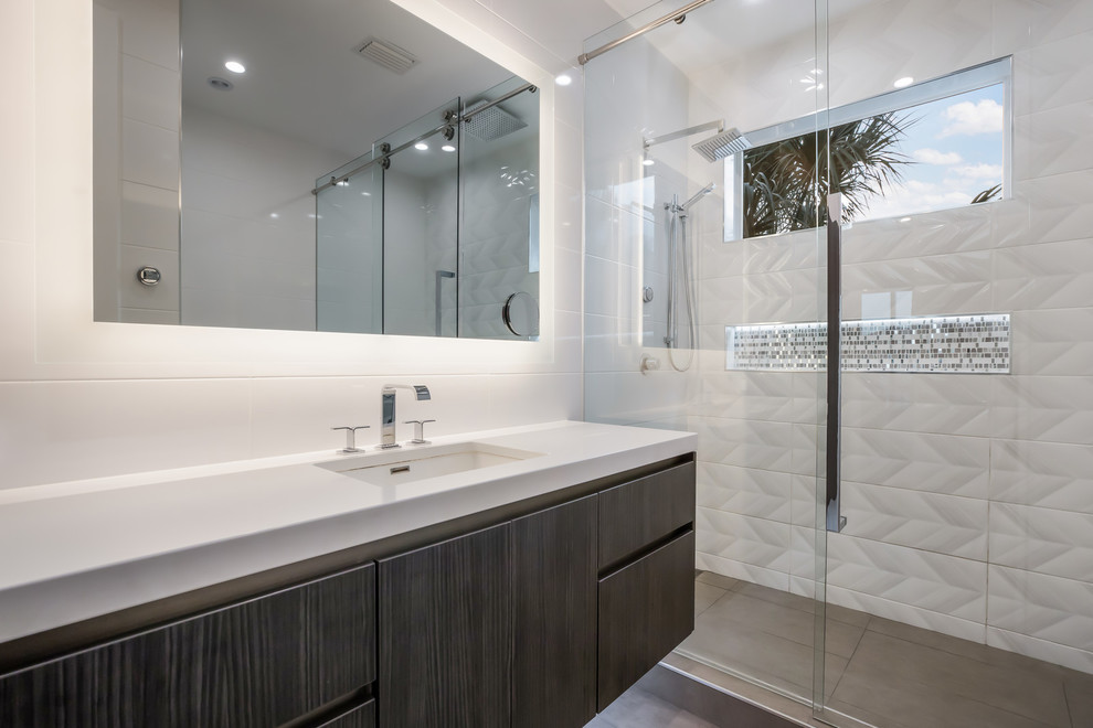 Example of a mid-sized minimalist multicolored tile and ceramic tile ceramic tile and gray floor sliding shower door design in Tampa with flat-panel cabinets, dark wood cabinets, a bidet, white walls, an undermount sink, quartz countertops and white countertops