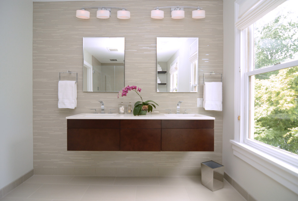 На фото: большая главная ванная комната в современном стиле с врезной раковиной, плоскими фасадами, фасадами цвета дерева среднего тона, мраморной столешницей, бежевой плиткой, стеклянной плиткой, бежевыми стенами и полом из известняка