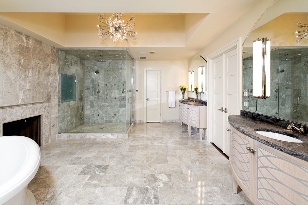 Modelo de cuarto de baño principal tradicional renovado extra grande con lavabo bajoencimera, bañera exenta, ducha esquinera, baldosas y/o azulejos grises y paredes beige