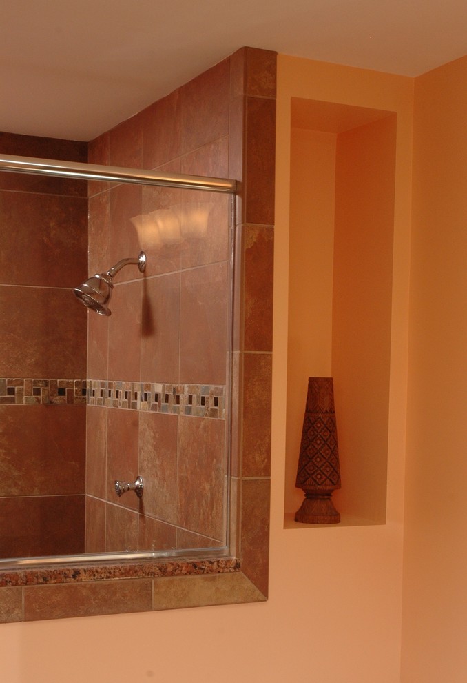 Example of a mid-sized classic master beige tile, brown tile, multicolored tile and ceramic tile ceramic tile and brown floor bathroom design in Cincinnati with furniture-like cabinets, dark wood cabinets, a two-piece toilet, orange walls, an undermount sink and granite countertops