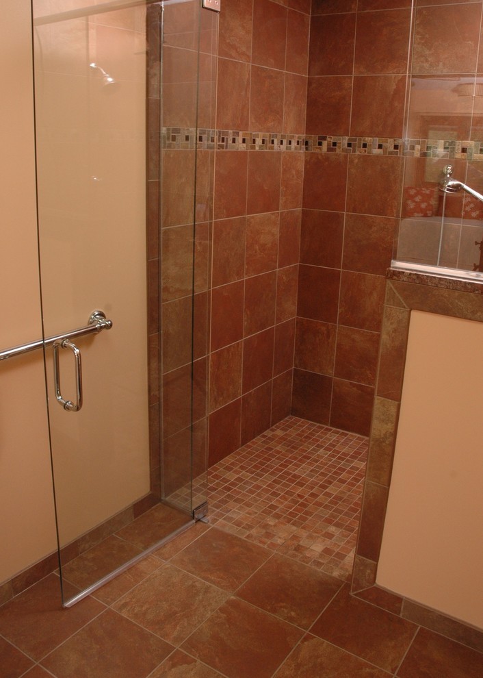 Photo of a medium sized classic ensuite bathroom in Cincinnati with freestanding cabinets, dark wood cabinets, a corner shower, a two-piece toilet, beige tiles, brown tiles, multi-coloured tiles, ceramic tiles, orange walls, ceramic flooring, a submerged sink, granite worktops, brown floors and a hinged door.