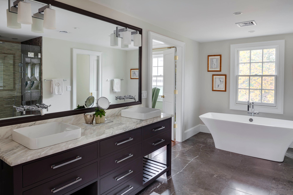 Example of a classic freestanding bathtub design in Boston with a vessel sink, dark wood cabinets and flat-panel cabinets