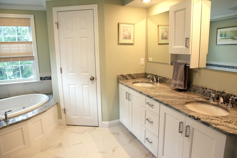Foto di una stanza da bagno padronale tradizionale di medie dimensioni con ante bianche, vasca da incasso, doccia ad angolo, pavimento in marmo e top in marmo