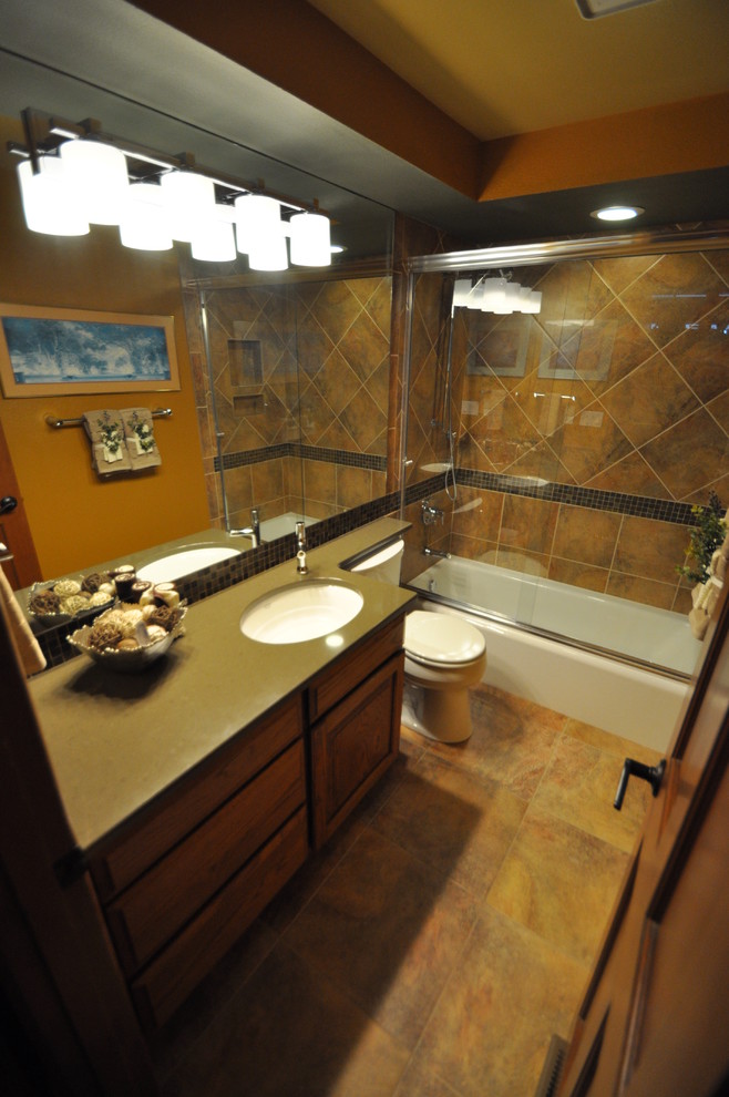 Стильный дизайн: маленькая ванная комната в стиле фьюжн с фасадами с утопленной филенкой, фасадами цвета дерева среднего тона, ванной в нише, душем над ванной, раздельным унитазом, разноцветной плиткой, керамогранитной плиткой, серыми стенами, полом из керамогранита, душевой кабиной, врезной раковиной и столешницей из искусственного кварца для на участке и в саду - последний тренд