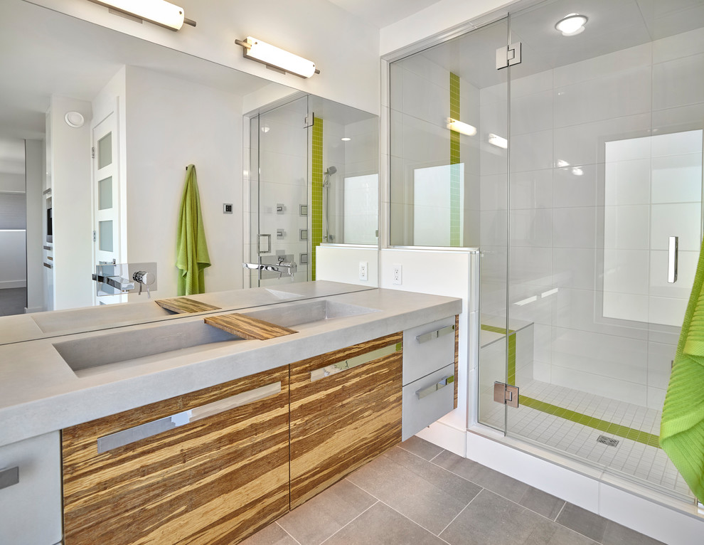 Inspiration for a medium sized contemporary shower room bathroom in Edmonton with flat-panel cabinets, medium wood cabinets, green tiles, glass tiles, white walls, cement flooring, concrete worktops, grey floors, a hinged door, grey worktops, an alcove shower and a trough sink.