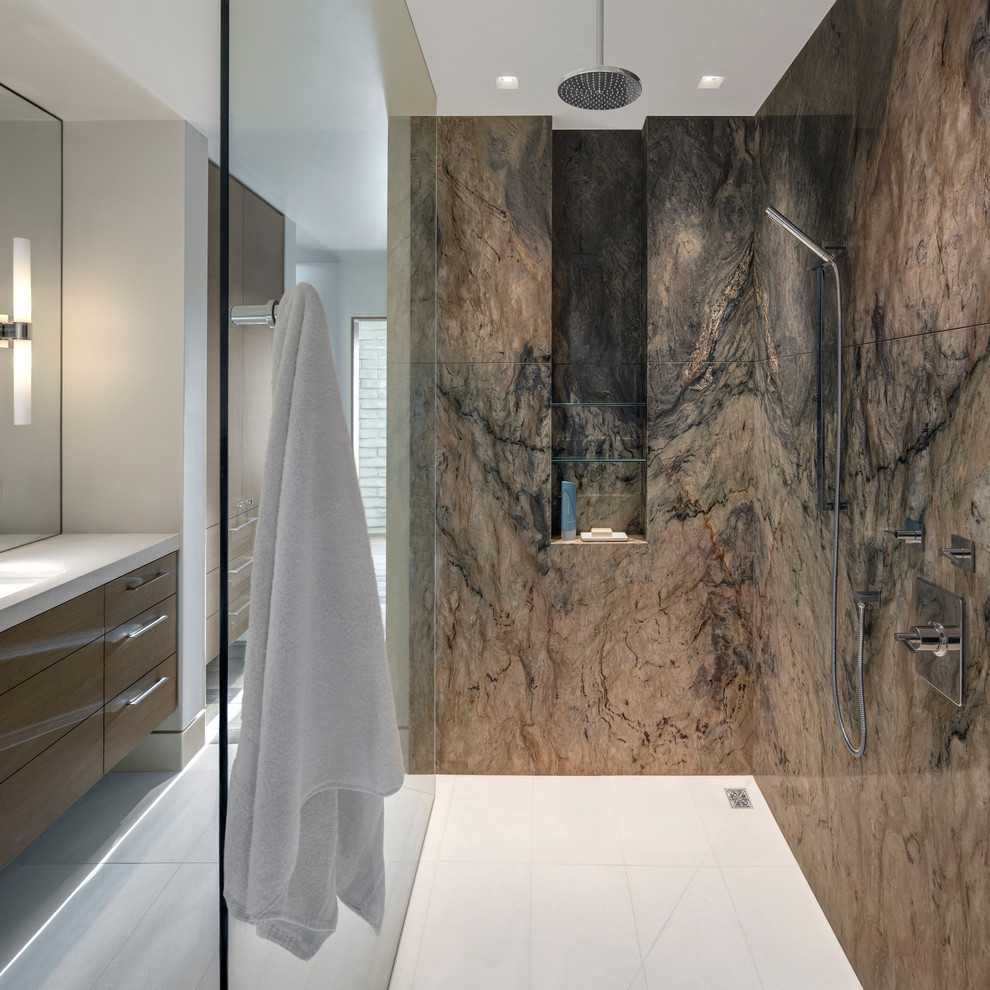 Cette image montre une salle de bain design en bois brun avec un placard à porte plane, un mur blanc, un lavabo encastré, un sol blanc et un plan de toilette blanc.