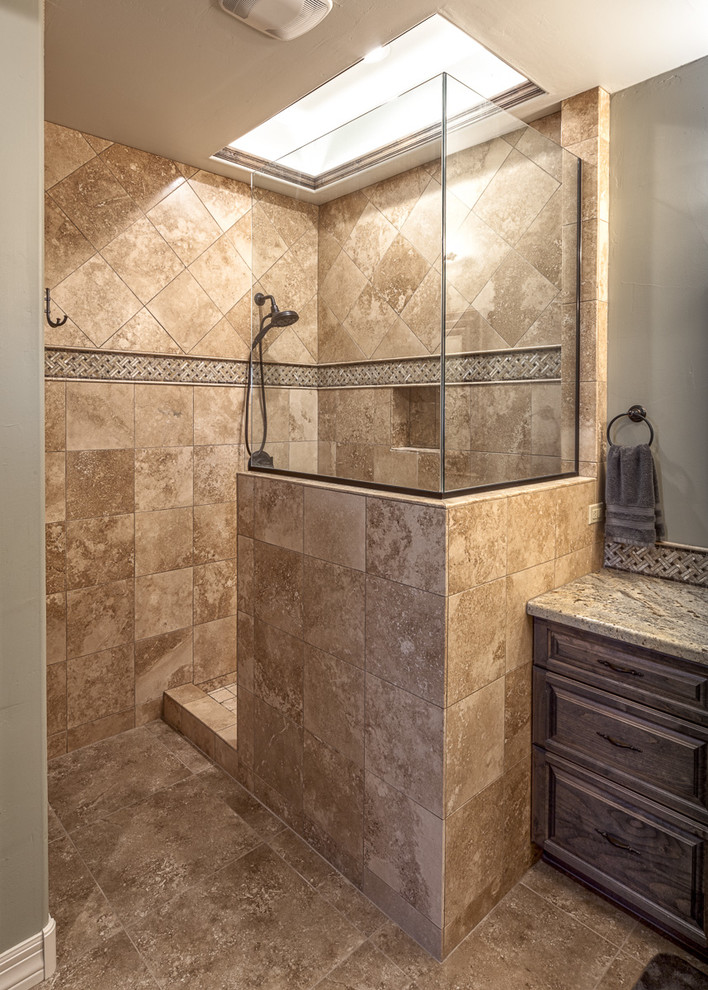 Exempel på ett mellanstort medelhavsstil en-suite badrum, med luckor med upphöjd panel, en öppen dusch, en toalettstol med hel cisternkåpa, beige kakel, stenkakel, gröna väggar, klinkergolv i keramik, granitbänkskiva, skåp i mörkt trä och beiget golv