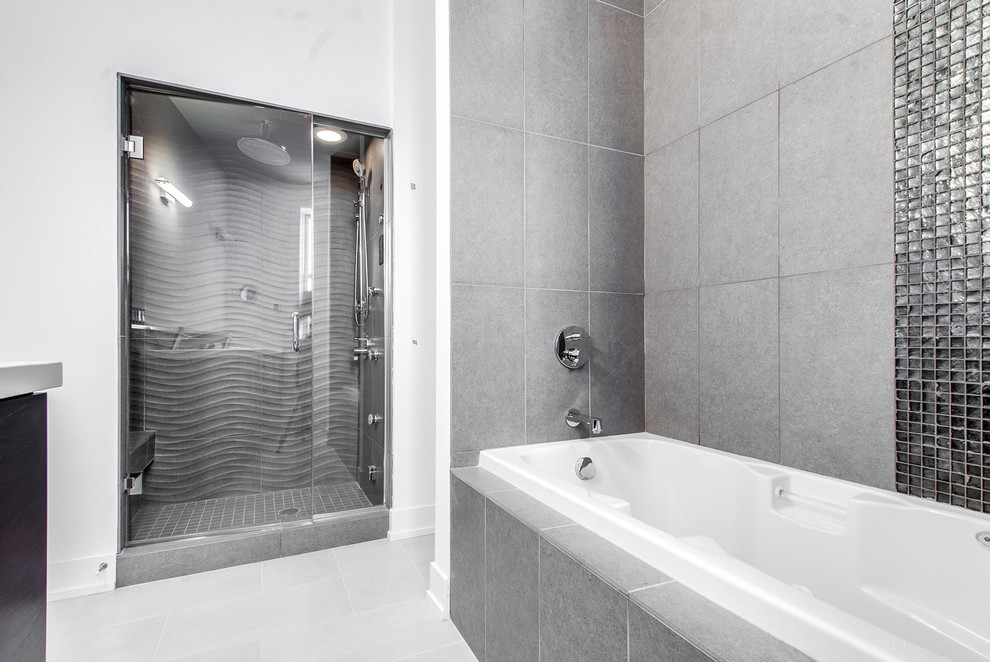 Imagen de cuarto de baño principal actual de tamaño medio con bañera esquinera, sanitario de una pieza, baldosas y/o azulejos grises, paredes blancas y suelo de baldosas de cerámica
