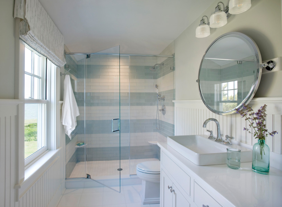 Inredning av ett maritimt vit vitt badrum, med skåp i shakerstil, vita skåp, en dusch i en alkov, flerfärgad kakel, grå väggar, ett fristående handfat, vitt golv och dusch med gångjärnsdörr