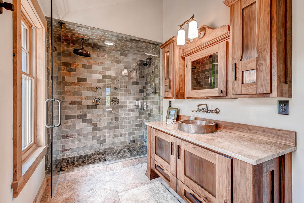 Mountain style 3/4 multicolored tile and subway tile beige floor and single-sink alcove shower photo in Denver with recessed-panel cabinets, medium tone wood cabinets, a vessel sink, a hinged shower door, beige countertops, a freestanding vanity and gray walls