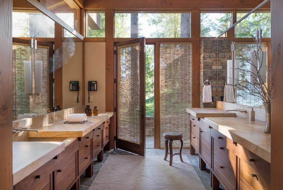 Ispirazione per una stanza da bagno stile rurale con lavabo integrato, ante in legno scuro, pareti beige e ante lisce