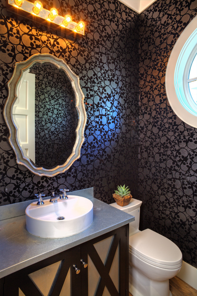 Small transitional medium tone wood floor bathroom photo in Orange County with a vessel sink, zinc countertops, a one-piece toilet, dark wood cabinets, black walls and recessed-panel cabinets