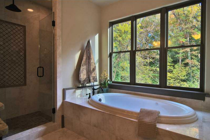На фото: большая главная ванная комната в средиземноморском стиле с коричневыми фасадами, накладной ванной, угловым душем, бежевыми стенами, мраморным полом, накладной раковиной, столешницей из гранита, белым полом и душем с распашными дверями с