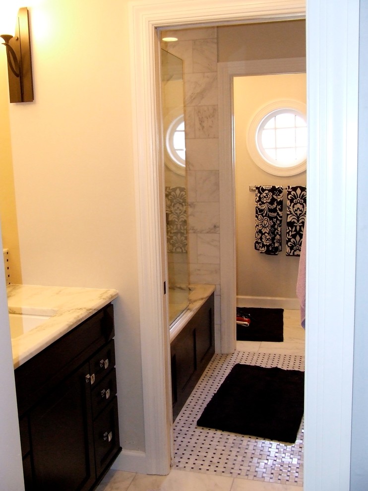 Example of a large trendy kids' white tile marble floor tub/shower combo design in St Louis with an undermount sink, flat-panel cabinets, dark wood cabinets, marble countertops, an undermount tub and beige walls