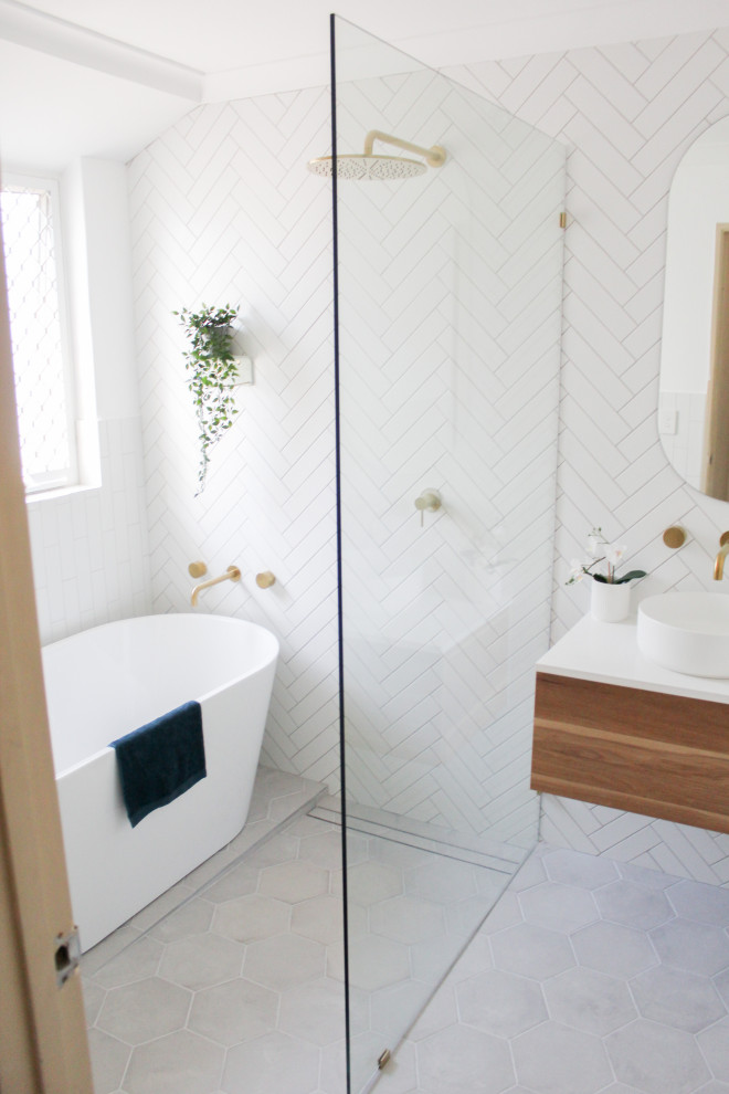 This is an example of a medium sized ensuite wet room bathroom in Perth with flat-panel cabinets, distressed cabinets, a freestanding bath, white tiles, ceramic tiles, white walls, mosaic tile flooring, a vessel sink, engineered stone worktops, grey floors, an open shower, white worktops, a single sink and a floating vanity unit.