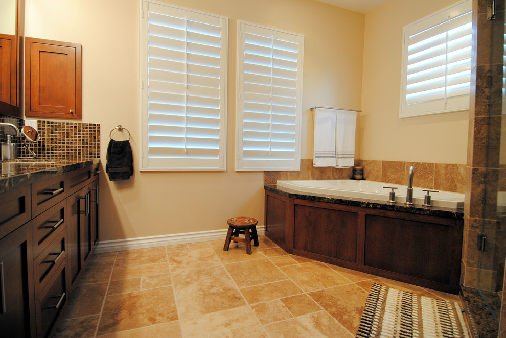 Пример оригинального дизайна: ванная комната в стиле неоклассика (современная классика) с врезной раковиной, фасадами в стиле шейкер, коричневыми фасадами, мраморной столешницей, угловой ванной и коричневой плиткой