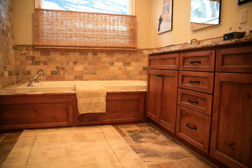 Пример оригинального дизайна: ванная комната среднего размера в стиле неоклассика (современная классика) с фасадами с утопленной филенкой, фасадами цвета дерева среднего тона, накладной ванной, бежевой плиткой, каменной плиткой, бежевыми стенами, полом из травертина, врезной раковиной и столешницей из гранита