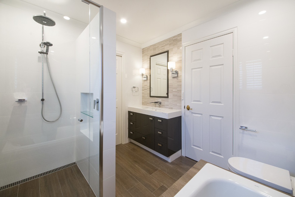This is an example of a medium sized traditional ensuite bathroom in Melbourne with flat-panel cabinets, grey cabinets, a built-in bath, a built-in shower, a one-piece toilet, brown tiles, porcelain tiles, white walls, porcelain flooring, a submerged sink, engineered stone worktops, brown floors, a hinged door and white worktops.