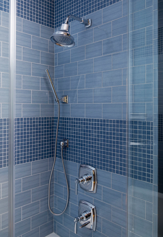 Cette image montre une salle de bain principale design de taille moyenne avec un placard en trompe-l'oeil, des portes de placard blanches, une douche d'angle, un carrelage bleu, des carreaux de céramique, un mur bleu, un lavabo encastré et un plan de toilette en marbre.