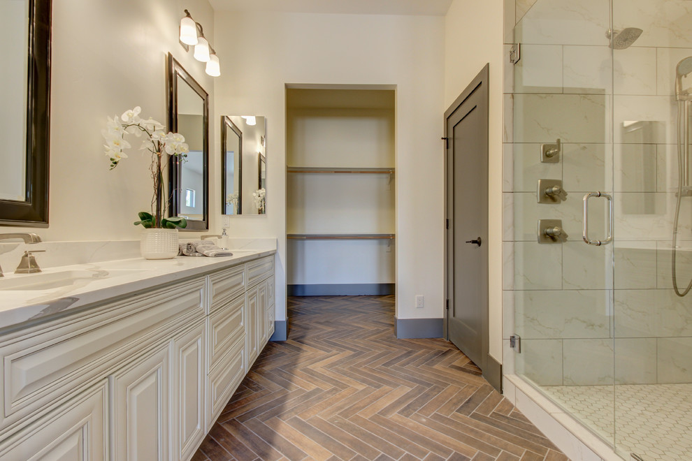 Idéer för ett klassiskt badrum, med luckor med upphöjd panel, vita skåp, en dusch i en alkov, grå kakel, marmorkakel, vita väggar, klinkergolv i porslin, ett undermonterad handfat, marmorbänkskiva, brunt golv och dusch med gångjärnsdörr