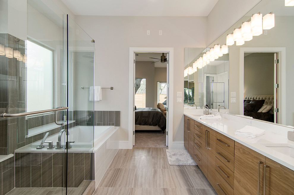 Immagine di una stanza da bagno tradizionale con lavabo sottopiano, ante lisce, ante in legno scuro, doccia ad angolo, piastrelle grigie, pareti grigie e vasca da incasso