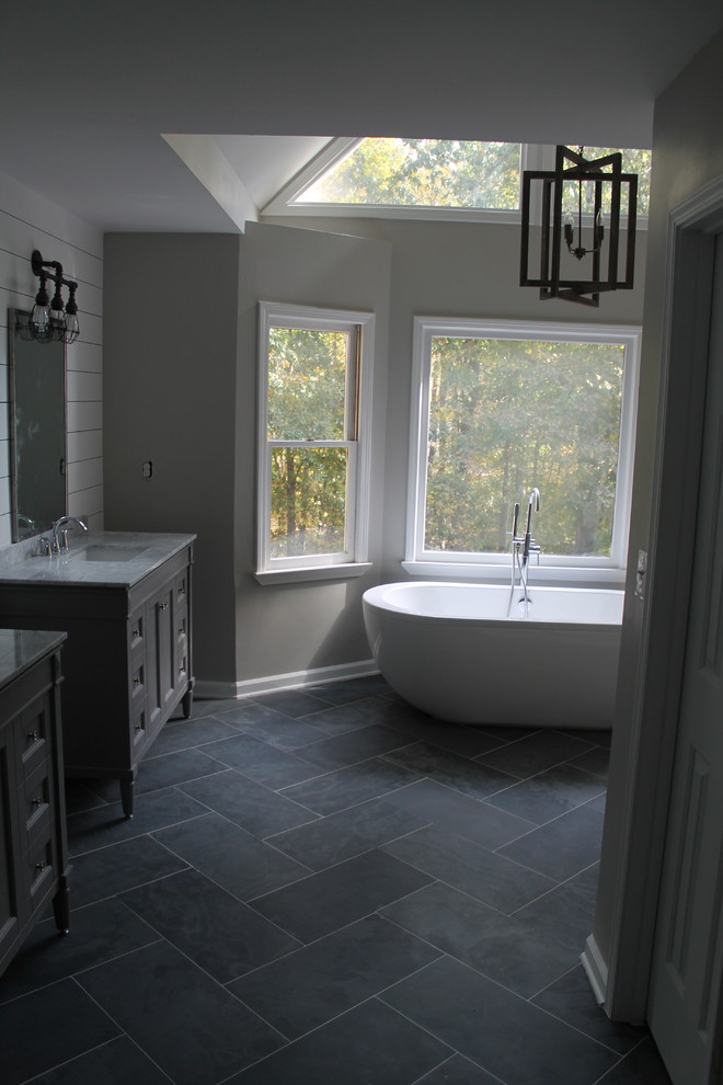 Пример оригинального дизайна: главная ванная комната среднего размера в стиле модернизм с фасадами с утопленной филенкой, серыми фасадами, отдельно стоящей ванной, открытым душем, раздельным унитазом, синей плиткой, каменной плиткой, серыми стенами, полом из сланца, врезной раковиной и мраморной столешницей