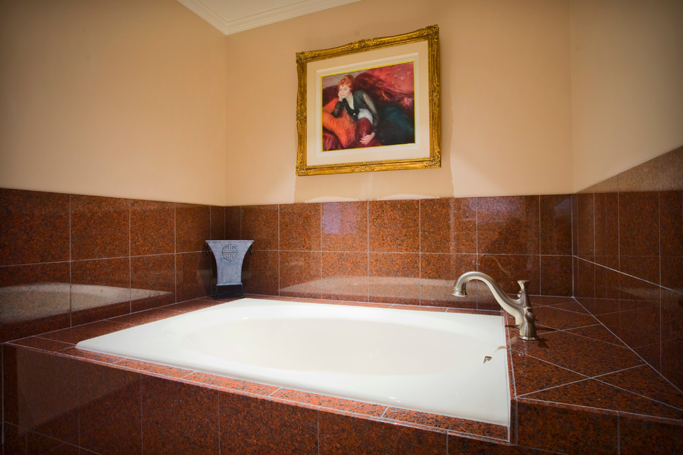 Modelo de cuarto de baño principal tradicional de tamaño medio con baldosas y/o azulejos marrones, baldosas y/o azulejos rojos, baldosas y/o azulejos de piedra, paredes marrones y bañera empotrada