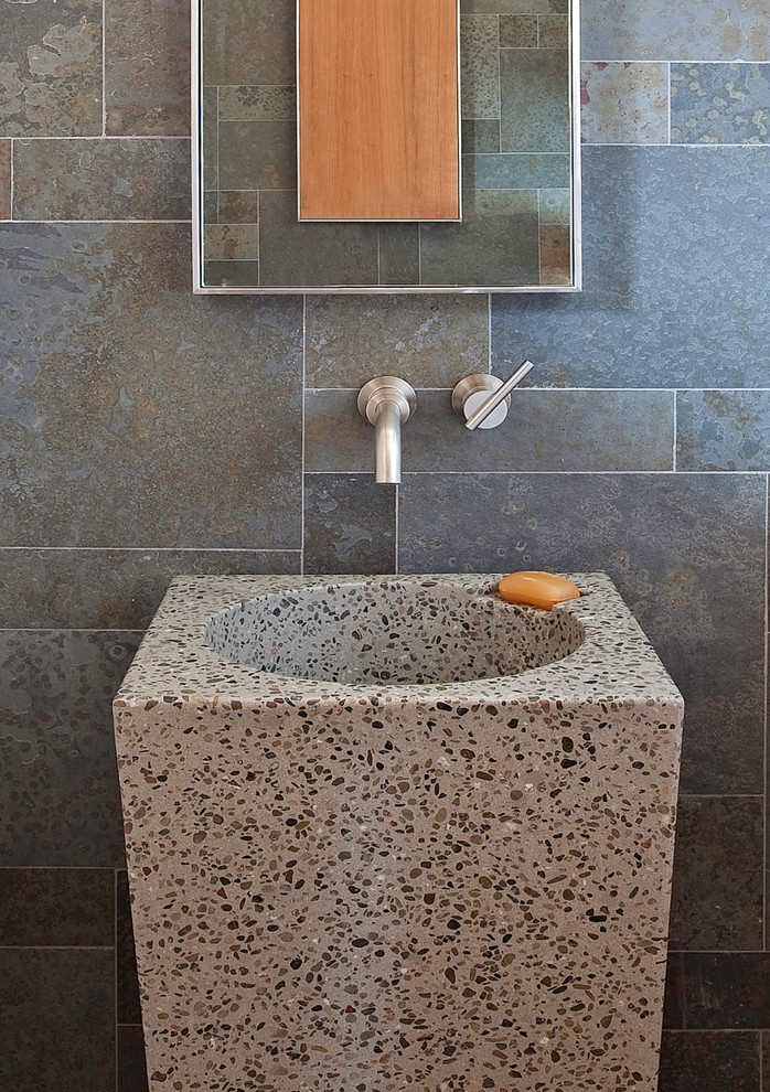 Ejemplo de cuarto de baño actual de tamaño medio con lavabo con pedestal, baldosas y/o azulejos de pizarra, paredes grises, suelo de cemento y suelo gris