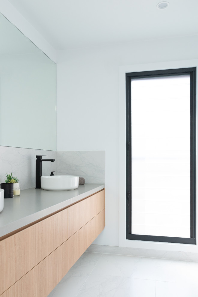 Idee per una stanza da bagno padronale contemporanea di medie dimensioni con ante lisce, ante in legno chiaro, top in quarzo composito e top grigio