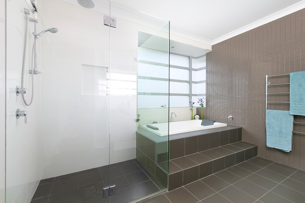 Стильный дизайн: ванная комната с угловой ванной, угловым душем, бежевой плиткой, коричневой плиткой, разноцветными стенами, подвесной раковиной и столешницей из гранита - последний тренд