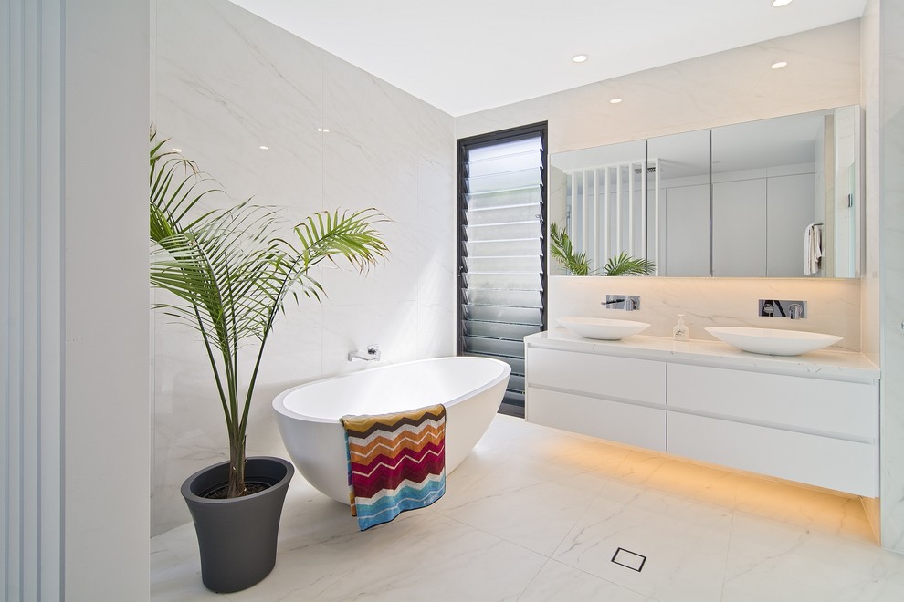 Foto de cuarto de baño contemporáneo con armarios con paneles lisos, puertas de armario blancas, bañera exenta, paredes blancas y lavabo sobreencimera