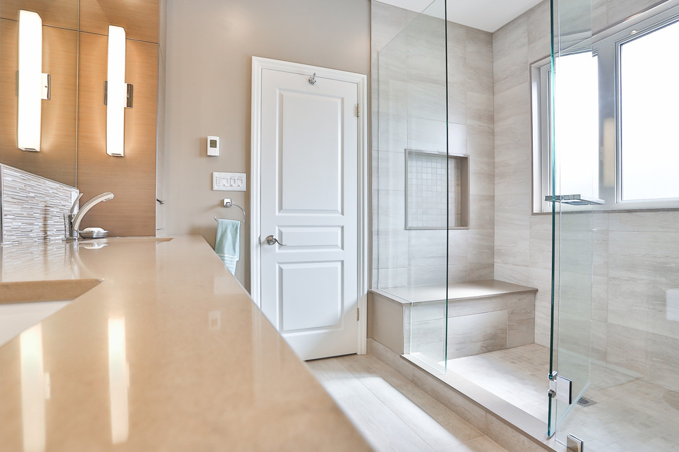 Exempel på ett stort modernt en-suite badrum, med släta luckor, grå skåp, en dusch i en alkov, en toalettstol med separat cisternkåpa, beige kakel, porslinskakel, grå väggar, klinkergolv i porslin, ett undermonterad handfat, bänkskiva i kvarts, beiget golv och dusch med gångjärnsdörr