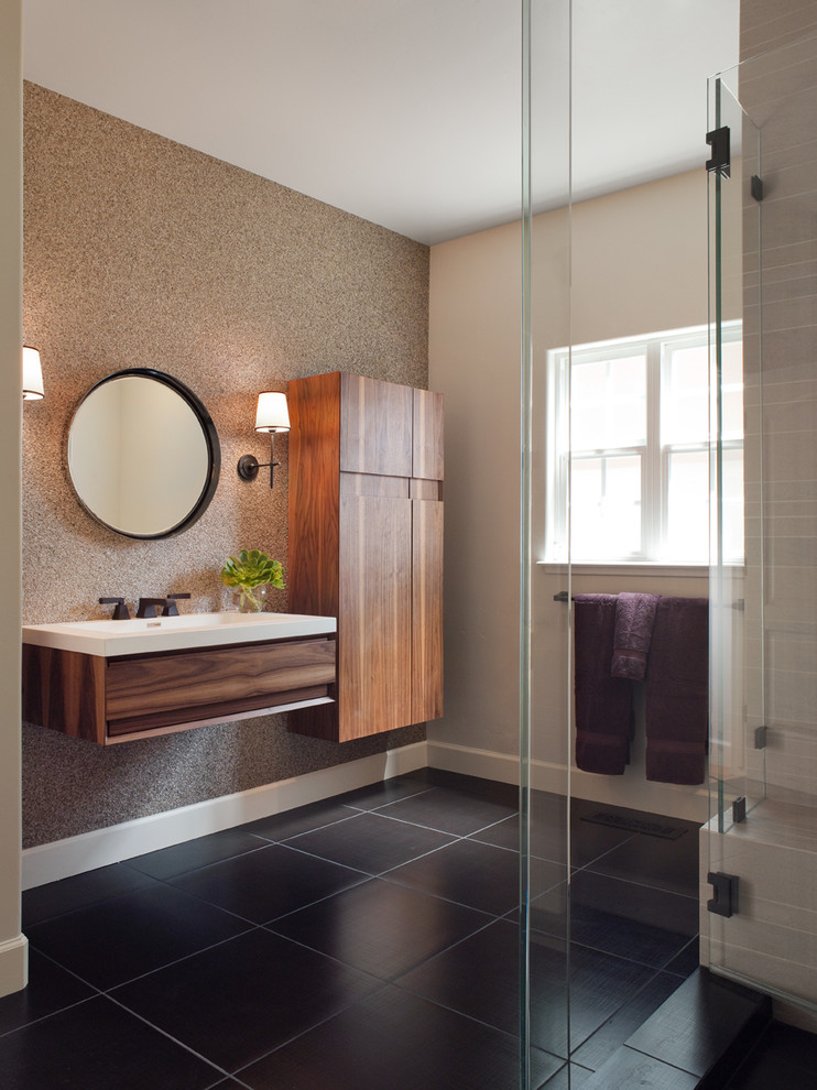 Example of a mid-sized trendy gray tile ceramic tile and brown floor corner shower design in San Francisco with a wall-mount sink, flat-panel cabinets, dark wood cabinets, a hinged shower door and beige walls