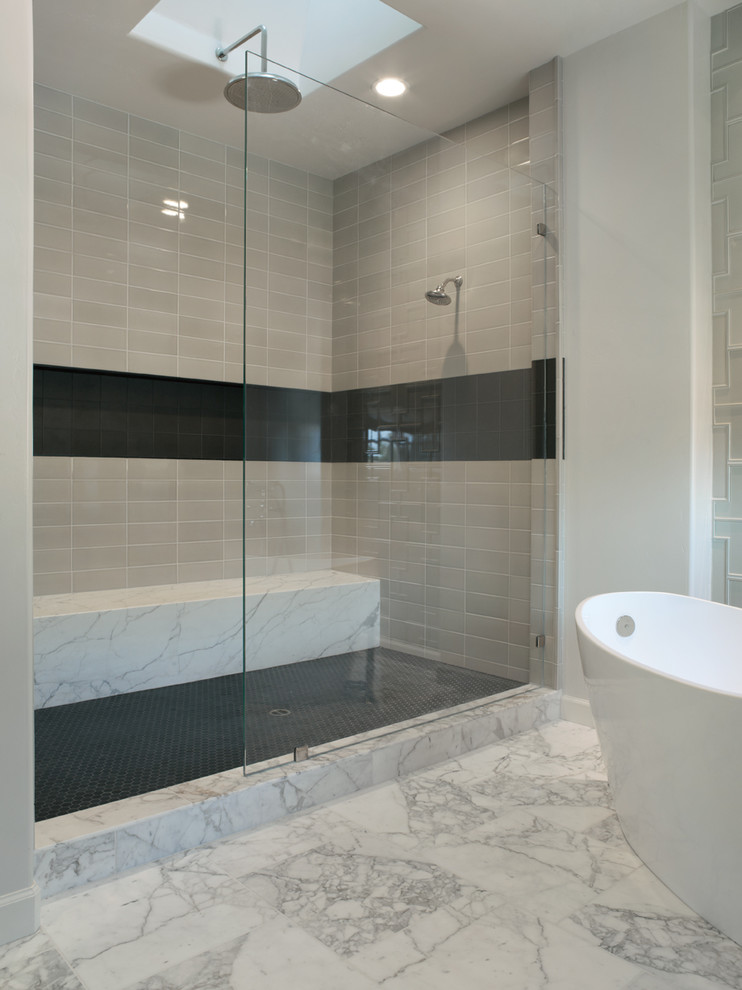 Exempel på ett modernt badrum, med ett fristående badkar, svart kakel och grå kakel