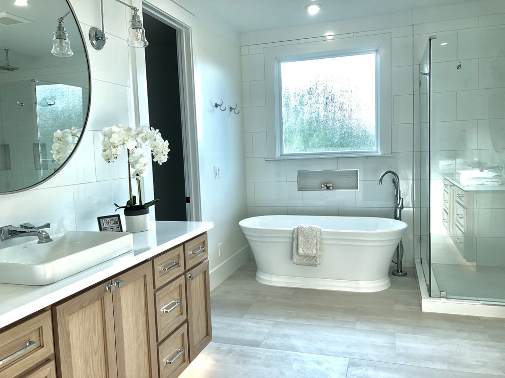 Exempel på ett stort maritimt vit vitt en-suite badrum, med skåp i shakerstil, skåp i ljust trä, ett fristående badkar, en hörndusch, vit kakel, porslinskakel, vita väggar, klinkergolv i porslin, ett fristående handfat, bänkskiva i kvartsit, beiget golv och dusch med gångjärnsdörr