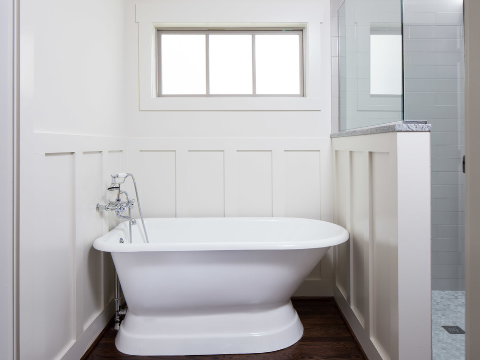 Foto de cuarto de baño principal actual de tamaño medio con armarios con rebordes decorativos, puertas de armario blancas, bañera exenta, ducha empotrada y suelo de madera oscura