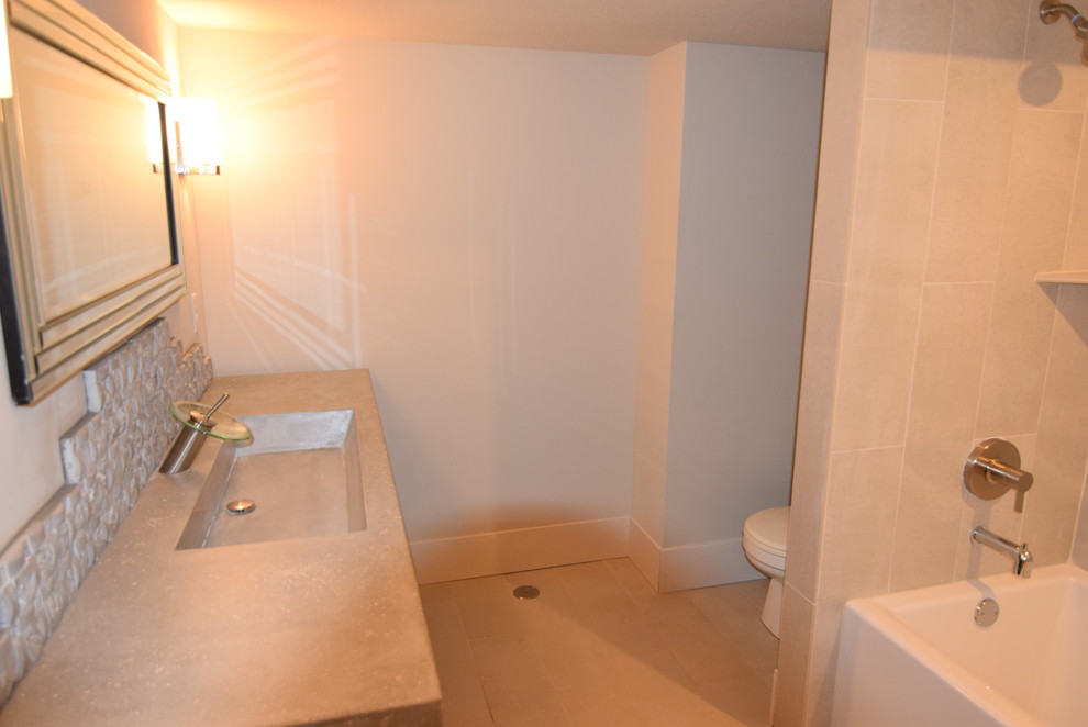 Cette photo montre une salle de bain tendance de taille moyenne pour enfant avec un mur gris, un lavabo intégré, un plan de toilette en béton et une cabine de douche avec un rideau.