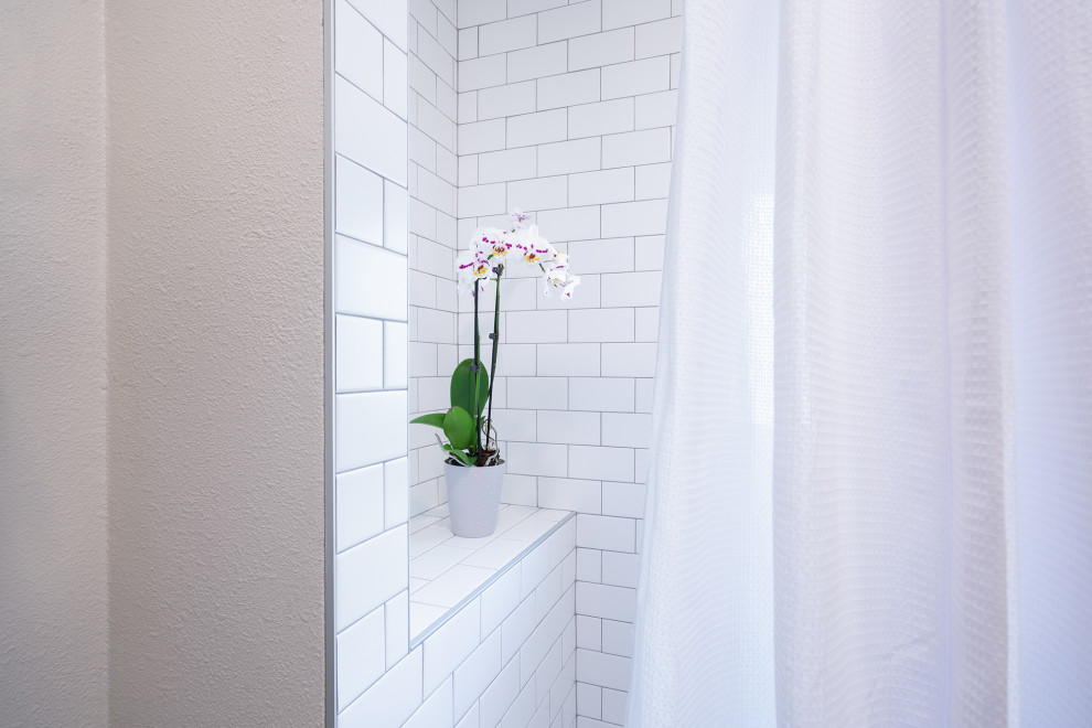 Cette image montre une petite salle de bain craftsman avec un placard à porte shaker, des portes de placard grises, une baignoire en alcôve, un combiné douche/baignoire, WC séparés, un carrelage blanc, des carreaux de céramique, un sol en carrelage de céramique, un lavabo encastré, un plan de toilette en marbre, un sol blanc, une cabine de douche avec un rideau, un plan de toilette blanc, une niche, meuble simple vasque, meuble-lavabo sur pied et du papier peint.